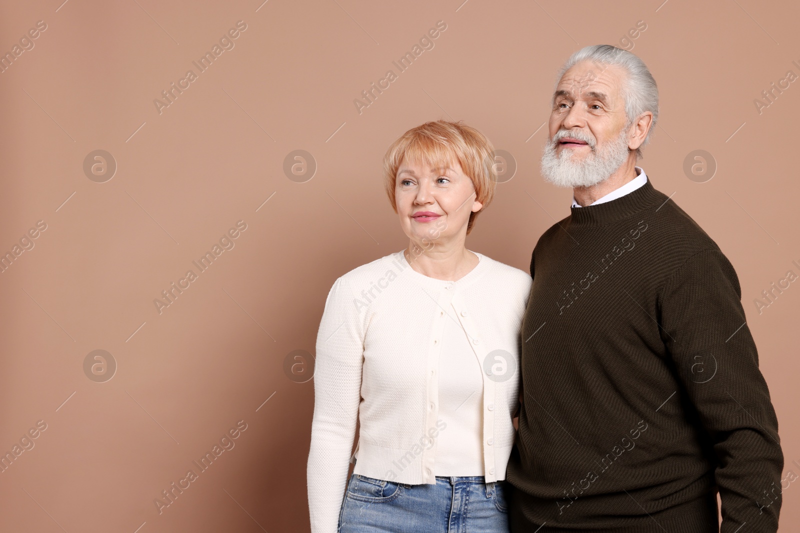 Photo of Lovely senior couple on beige background. Space for text