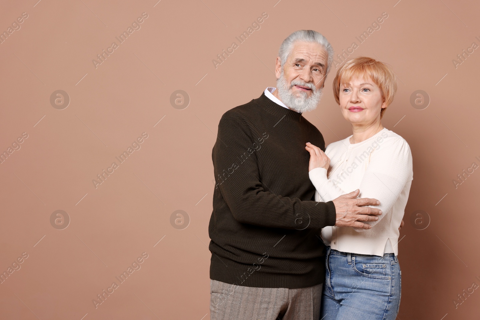 Photo of Lovely senior couple on beige background. Space for text