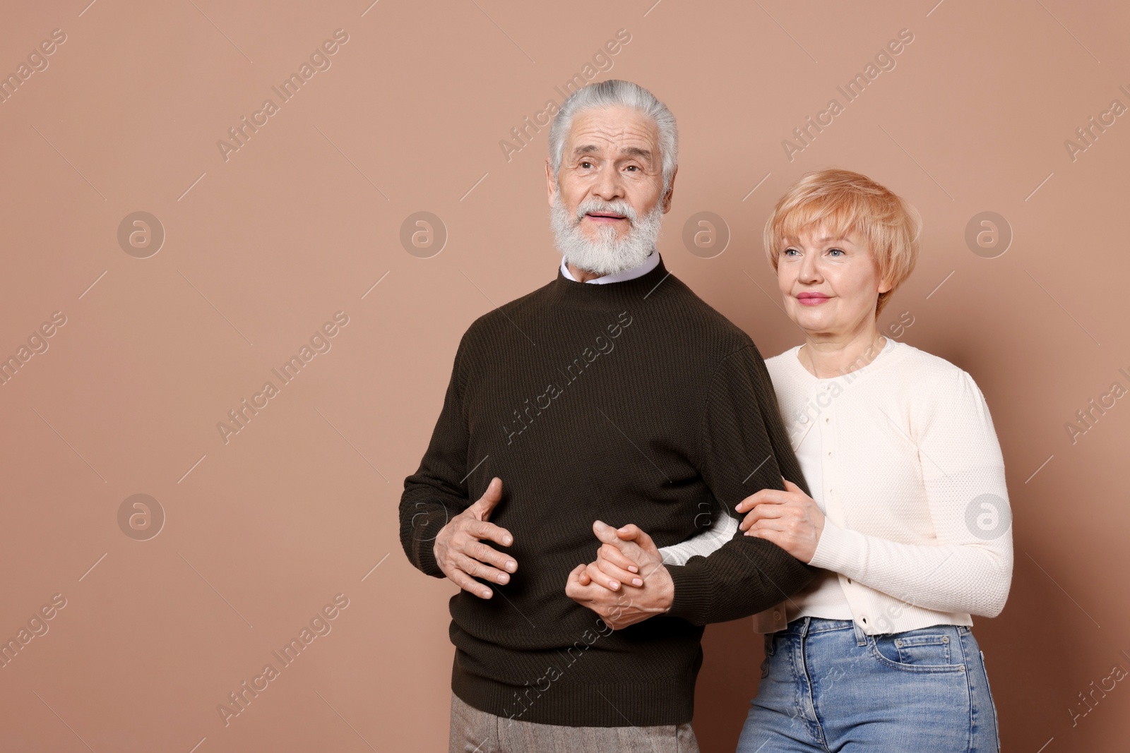 Photo of Lovely senior couple on beige background. Space for text