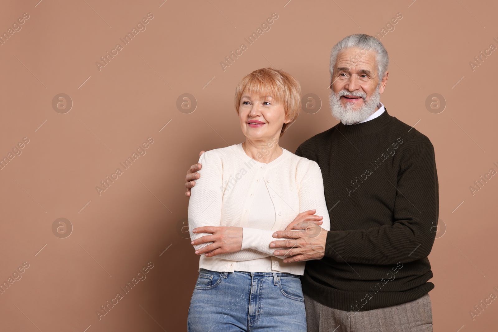 Photo of Happy senior couple on beige background. Space for text