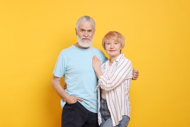 Portrait of lovely senior couple on orange background