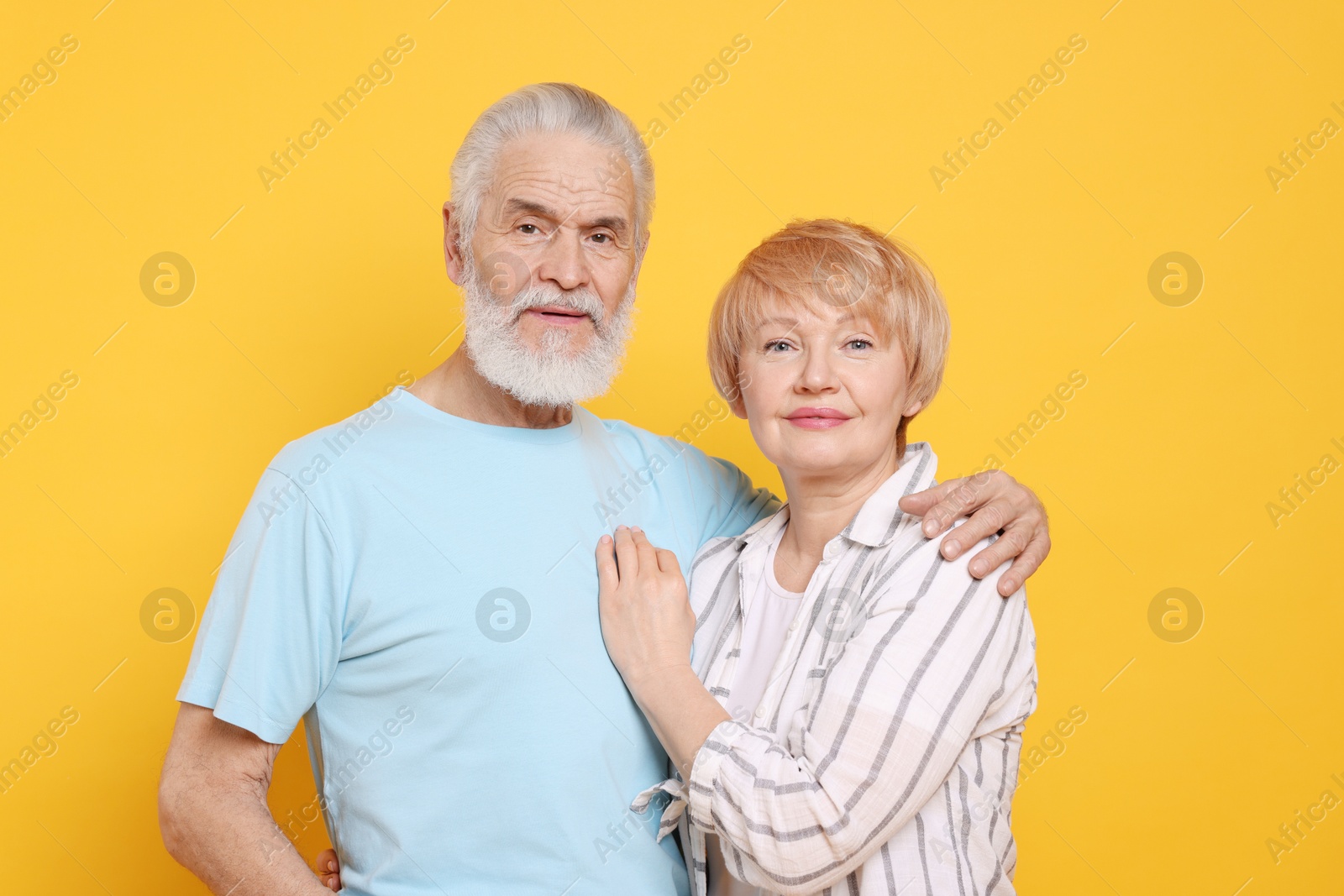 Photo of Portrait of lovely senior couple on orange background