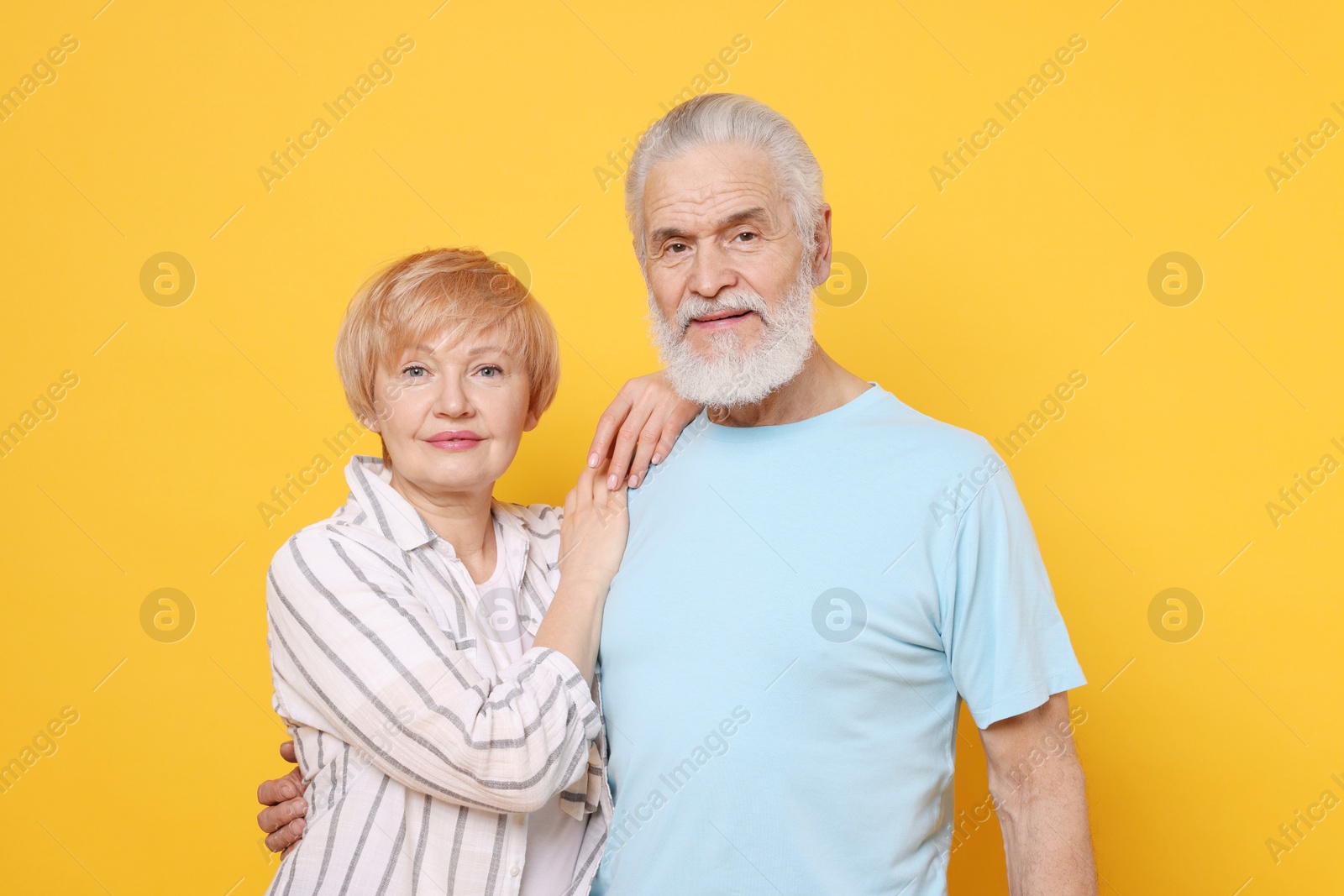 Photo of Portrait of lovely senior couple on orange background