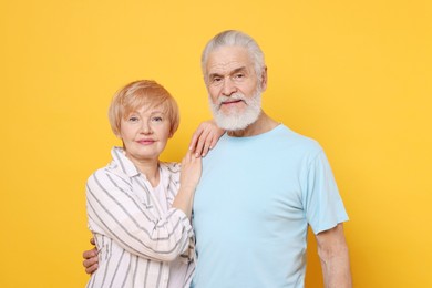 Photo of Portrait of lovely senior couple on orange background