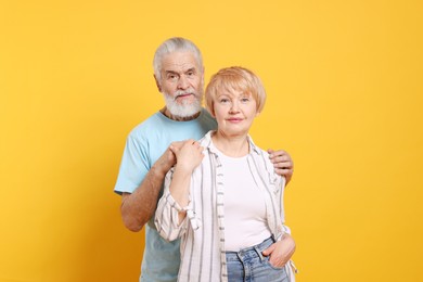 Portrait of lovely senior couple on orange background