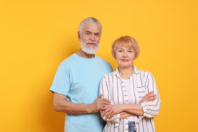 Portrait of lovely senior couple on orange background