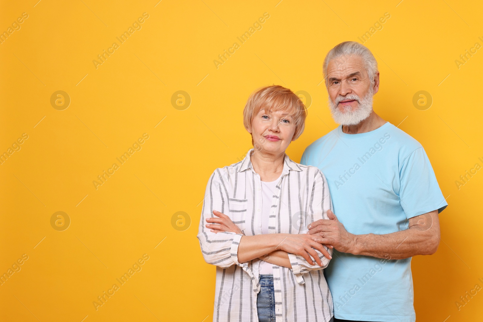 Photo of Portrait of lovely senior couple on orange background. Space for text