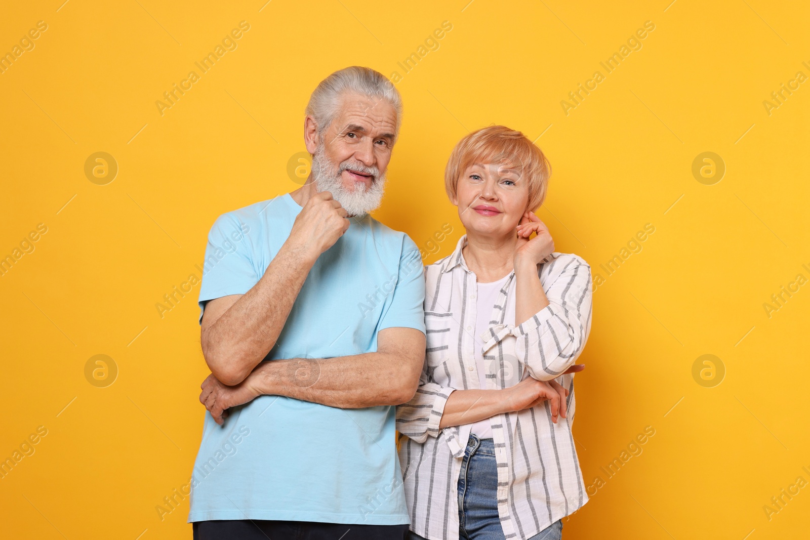 Photo of Portrait of lovely senior couple on orange background