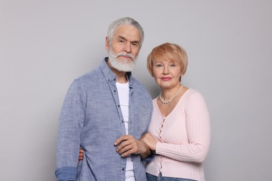 Portrait of lovely senior couple on grey background