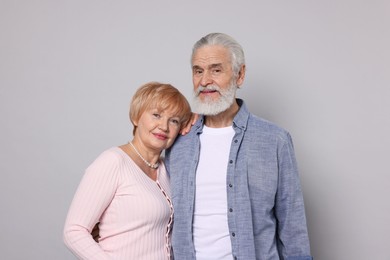 Portrait of lovely senior couple on grey background