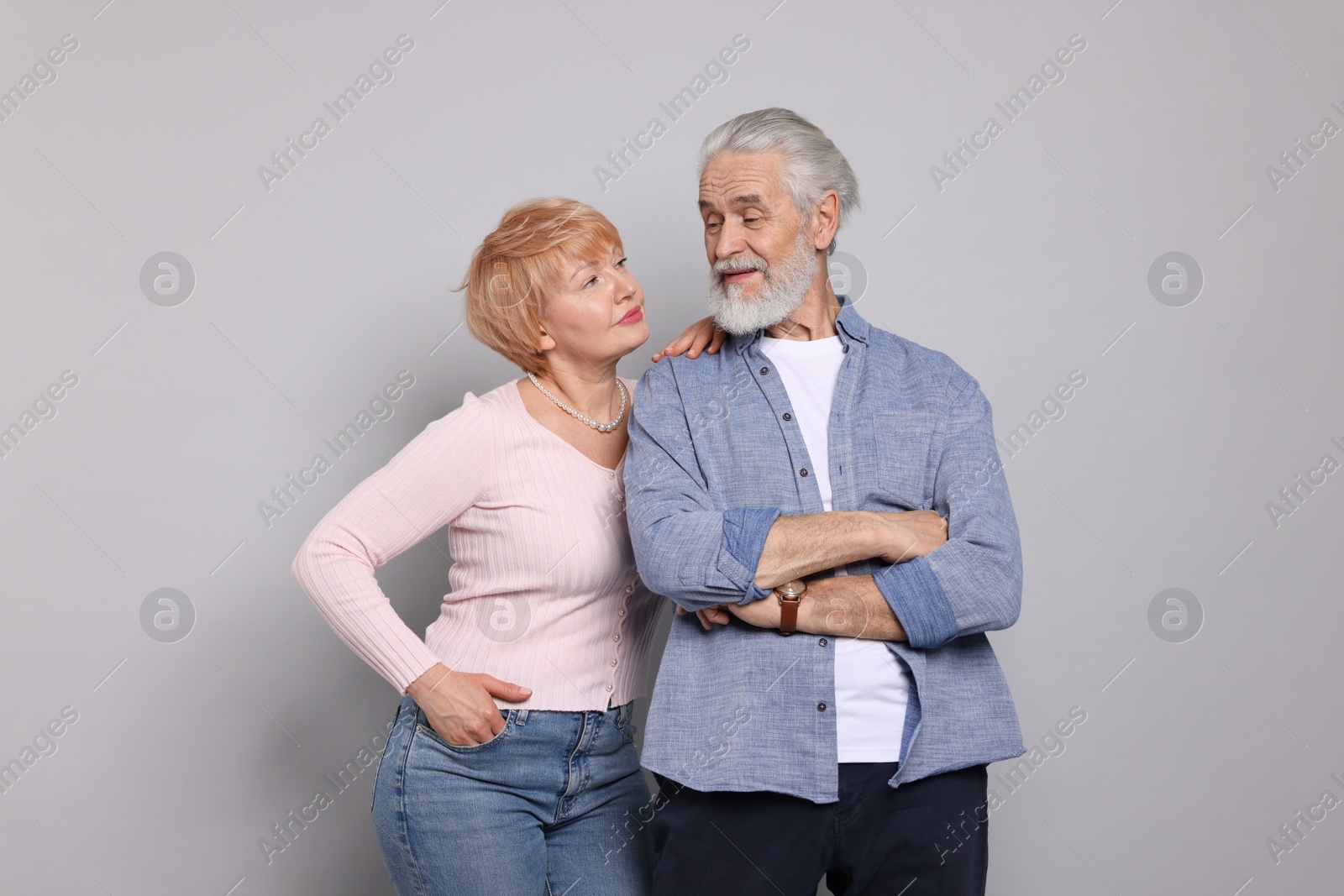 Photo of Lovely senior couple looking at each other on grey background