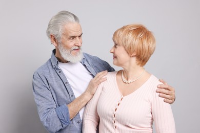 Photo of Lovely senior couple looking at each other on grey background