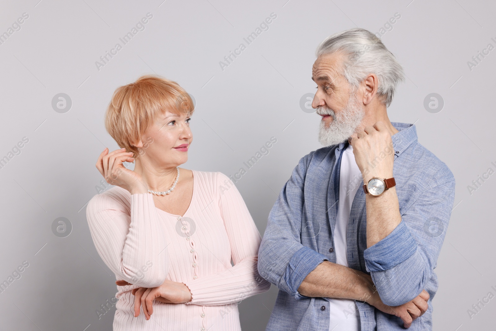 Photo of Lovely senior couple looking at each other on grey background