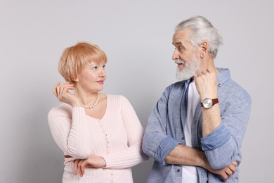 Lovely senior couple looking at each other on grey background