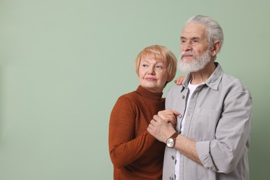 Photo of Lovely senior couple holding hands on green background. Space for text