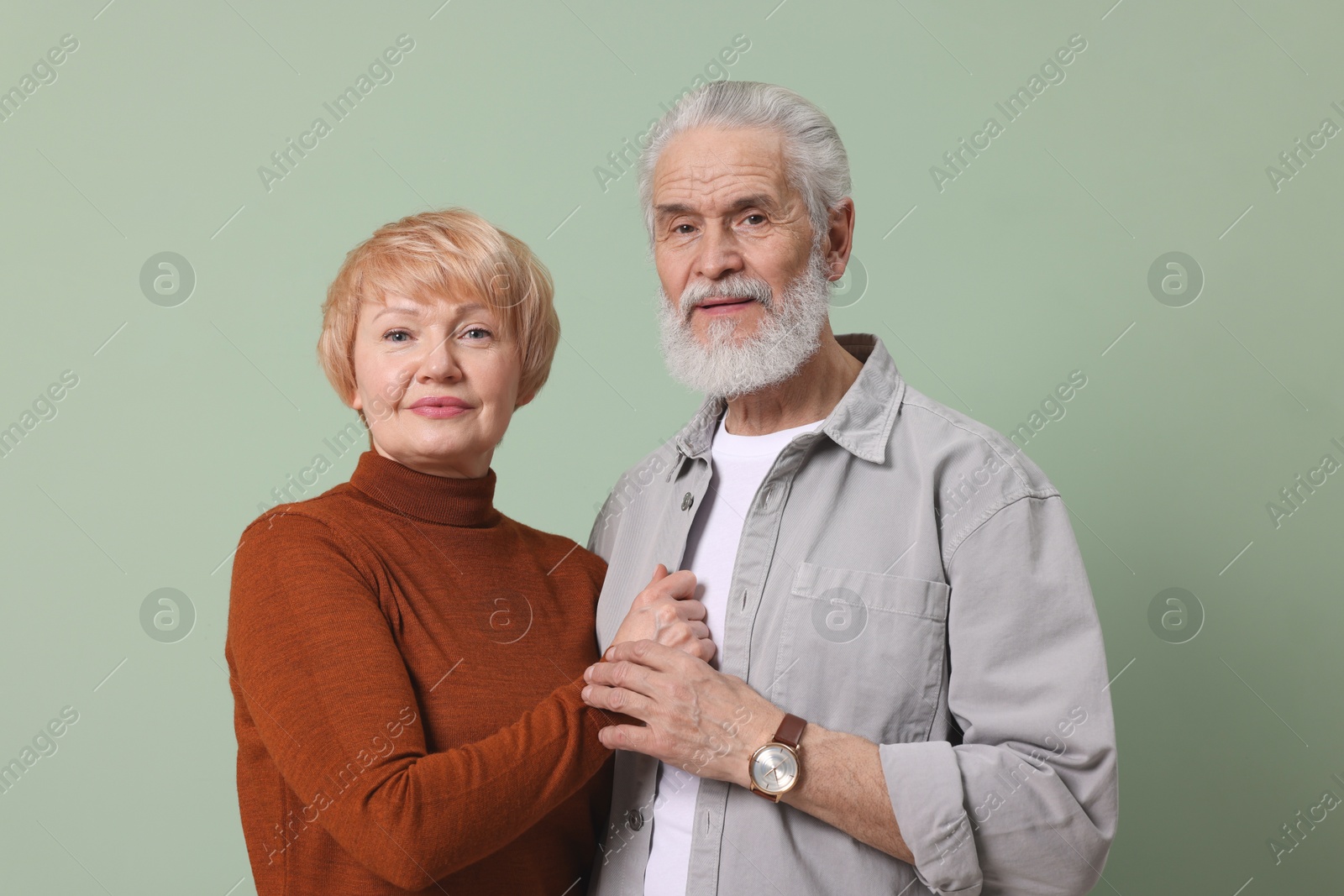 Photo of Portrait of lovely senior couple holding hands on green background