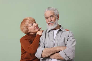 Photo of Lovely senior couple posing on green background