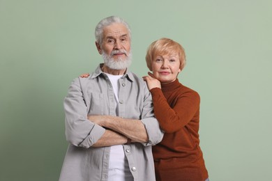 Portrait of lovely senior couple on green background