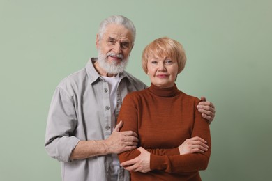 Portrait of lovely senior couple on green background