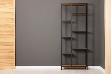 Photo of Empty shelving unit and folding screen near grey wall indoors, space for text