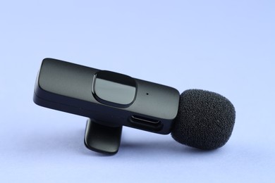 Photo of Lavalier microphone on light blue background, closeup