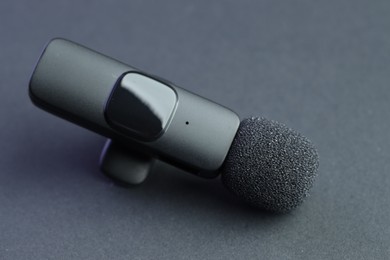 Photo of Modern lavalier microphone on grey background, closeup