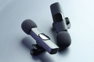 Photo of Lavalier microphones on light grey background, closeup