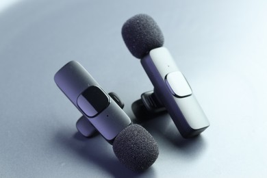 Photo of Lavalier microphones on light grey background, closeup