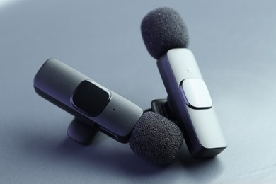 Photo of Lavalier microphones on light grey background, closeup