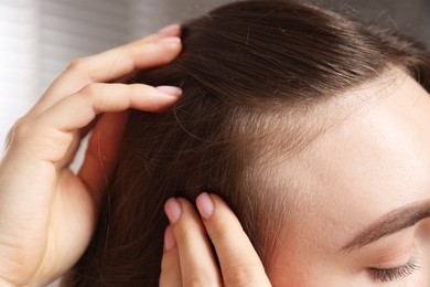 Woman with healthy hair roots on blurred background, closeup