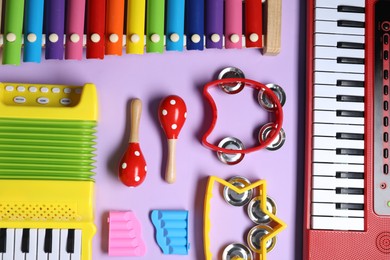 Photo of Different toy musical instruments on violet background, flat lay