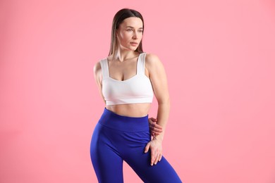 Photo of Woman in sportswear posing on pink background