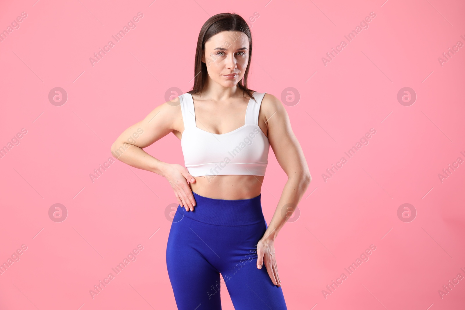 Photo of Woman in sportswear posing on pink background