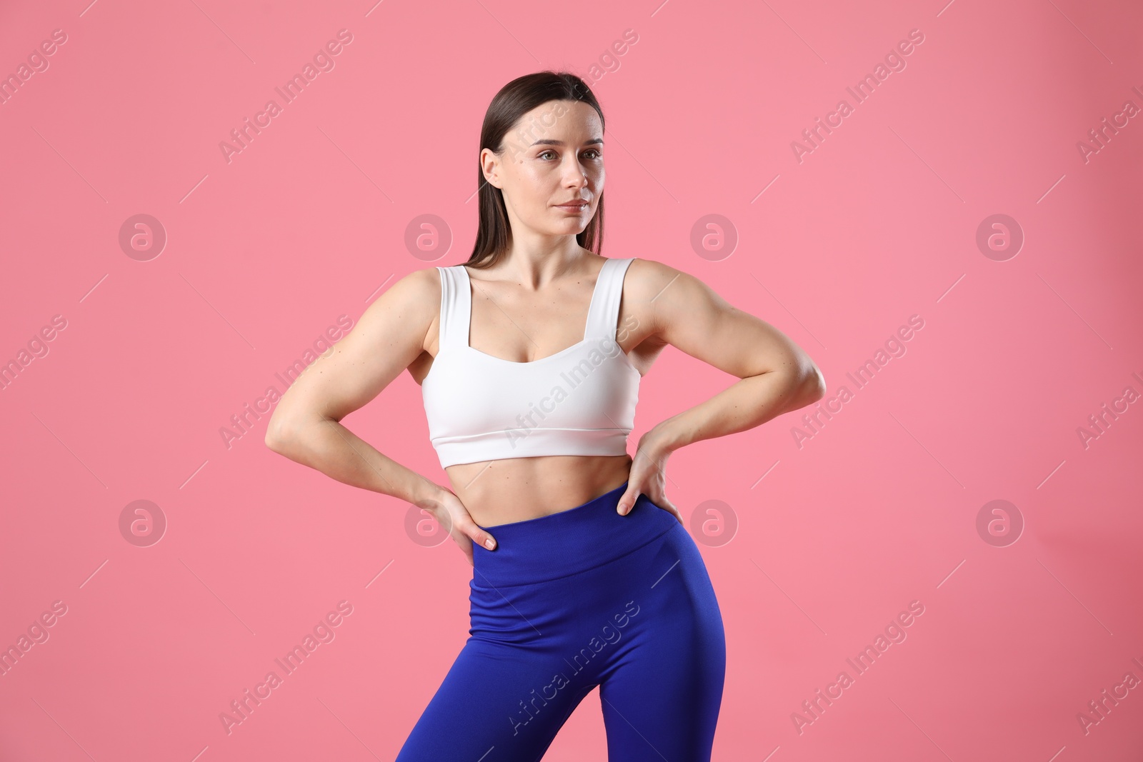 Photo of Woman in sportswear posing on pink background