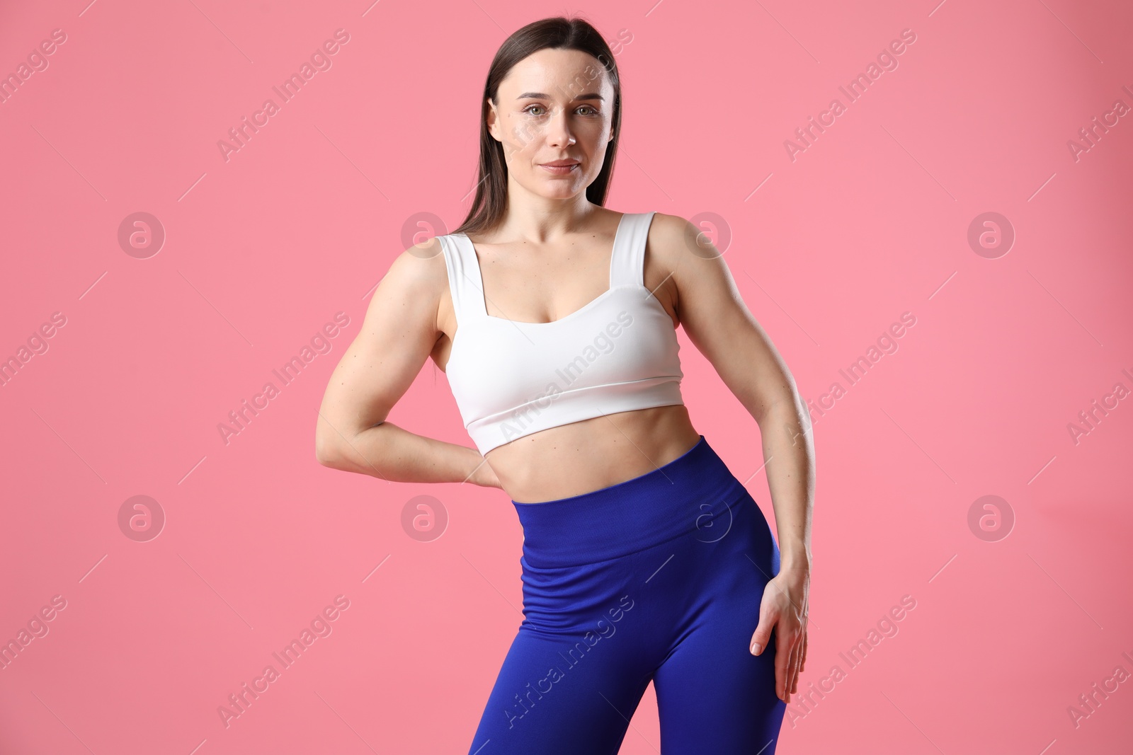 Photo of Woman in sportswear posing on pink background