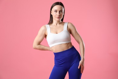 Photo of Woman in sportswear posing on pink background