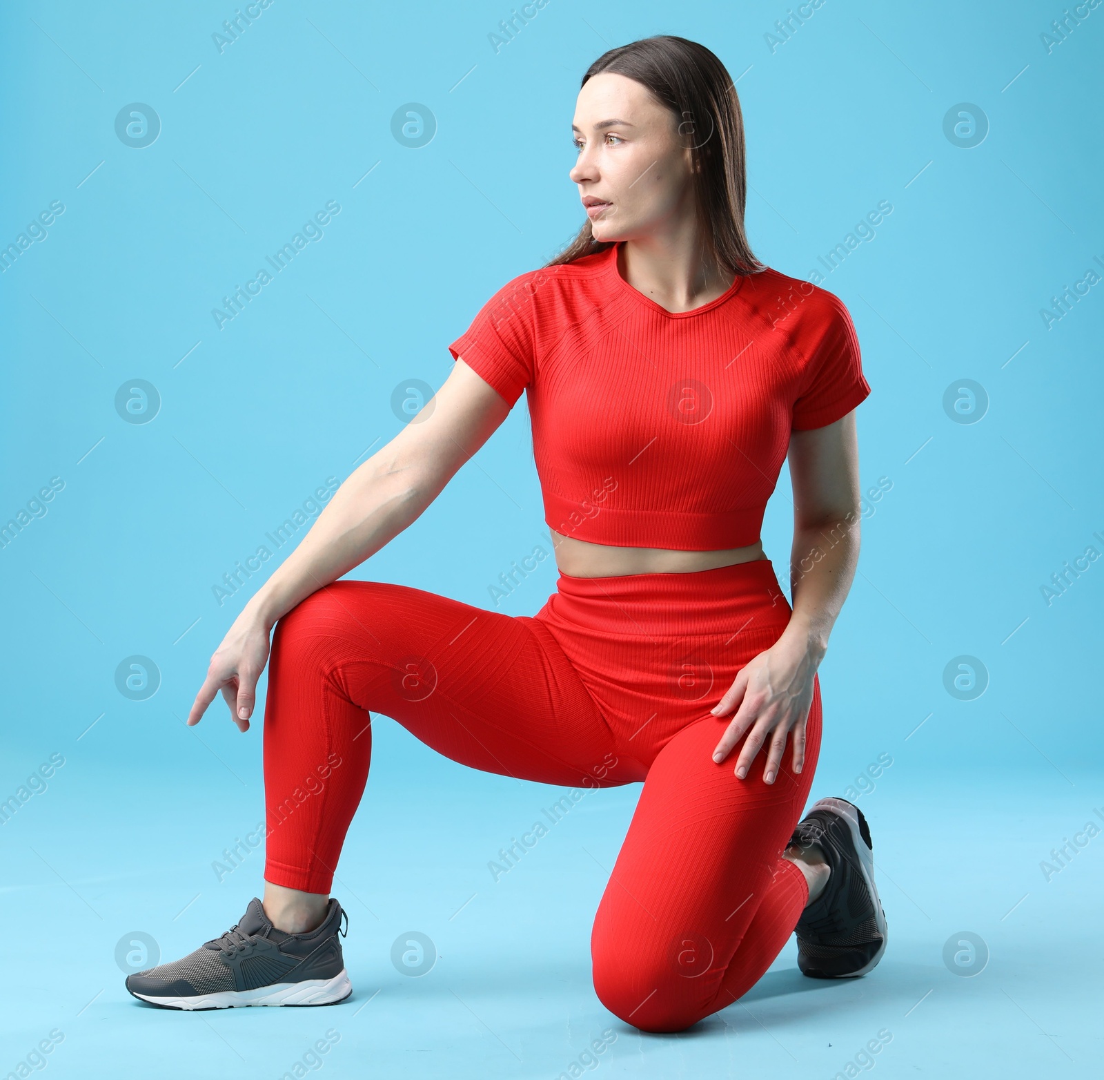 Photo of Woman in sportswear posing on light blue background