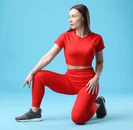 Photo of Woman in sportswear posing on light blue background