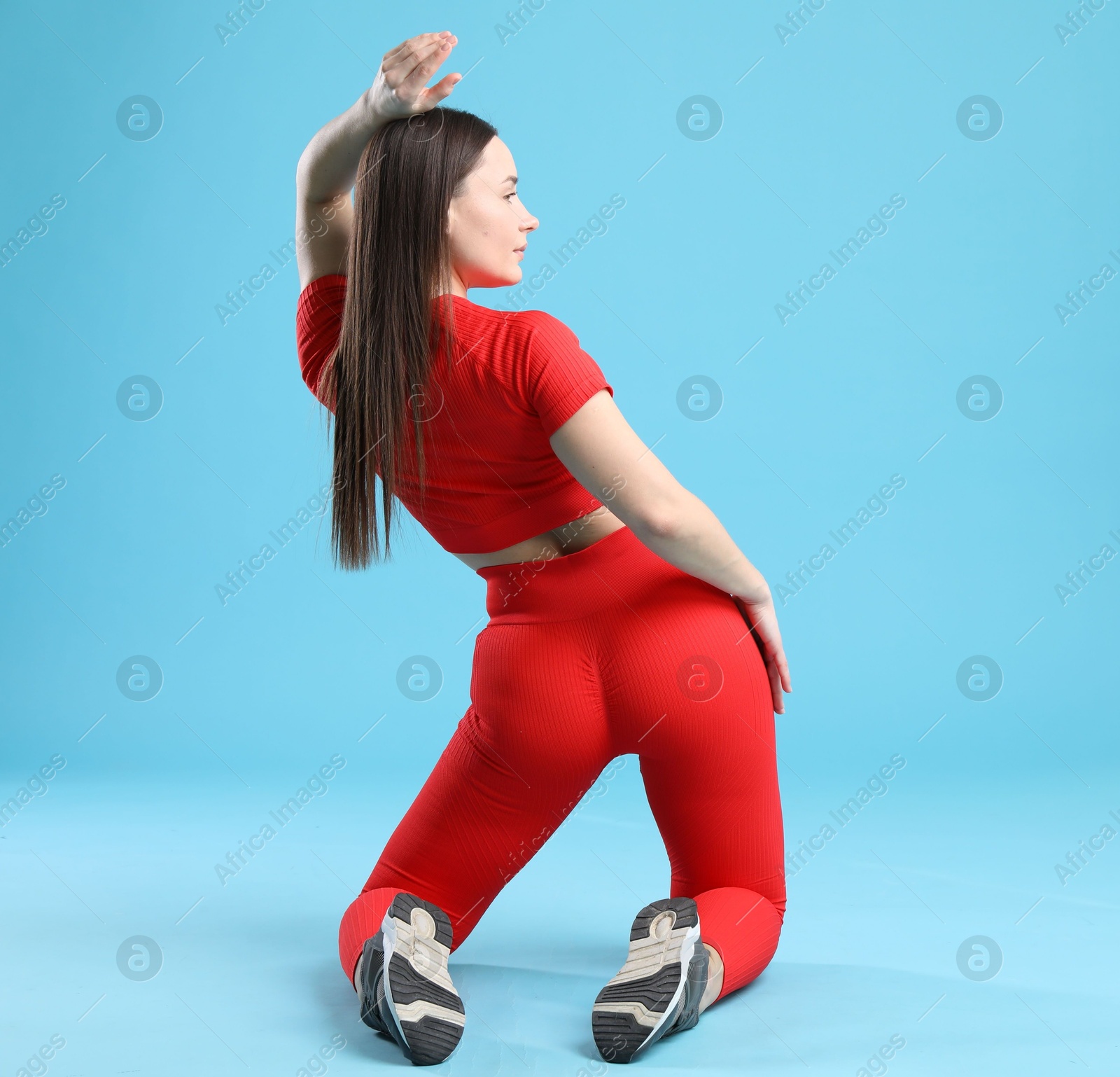 Photo of Woman in sportswear posing on light blue background