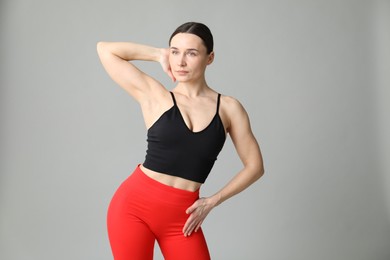 Photo of Woman in sportswear posing on grey background