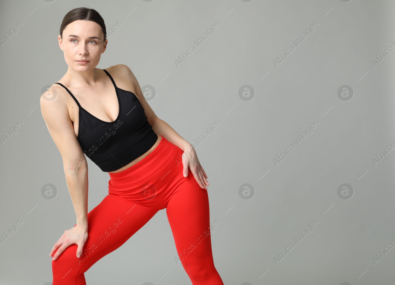 Photo of Woman in sportswear posing on grey background, space for text