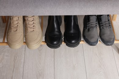 Photo of Stand with different stylish shoes indoors, above view. Space for text