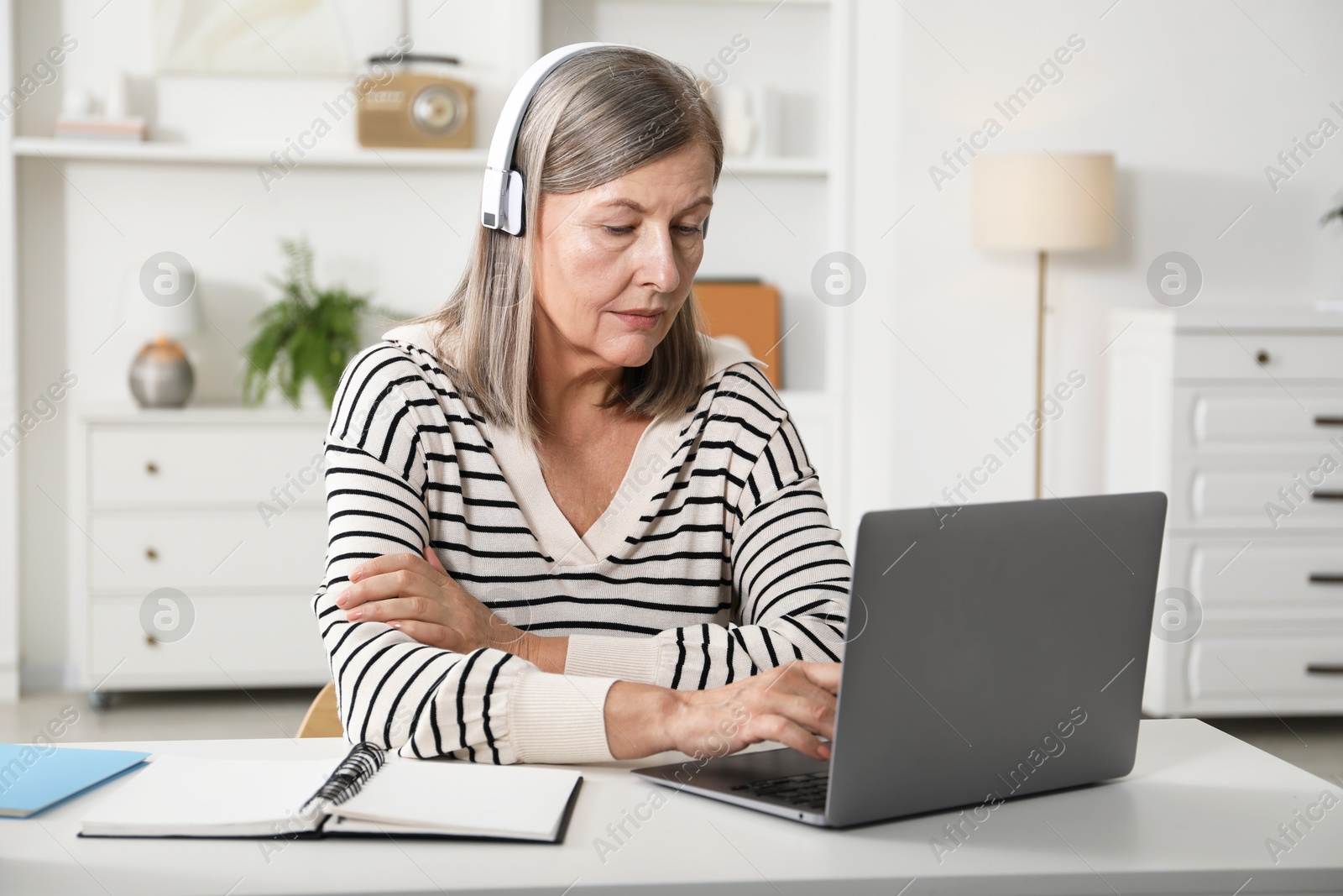 Photo of Woman learning online using laptop at table indoors. Self-study