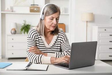 Photo of Woman learning online using laptop at table indoors. Self-study