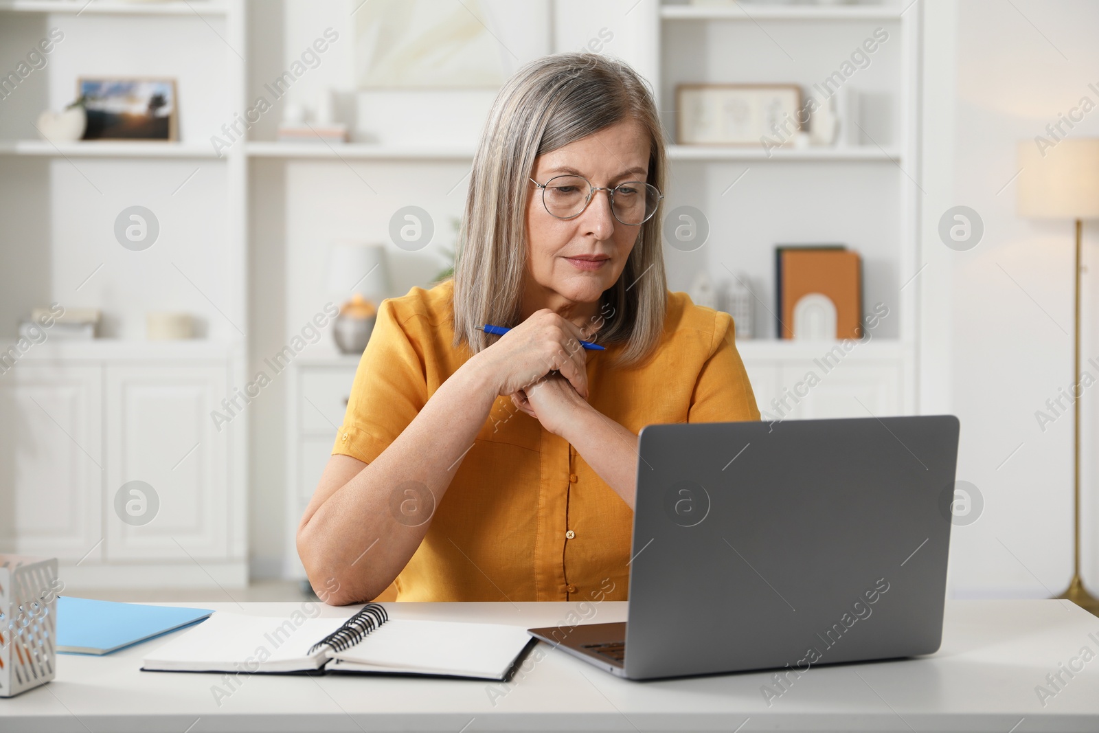 Photo of Woman learning online using laptop at table indoors. Self-study