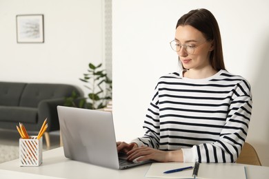 Photo of Woman learning online using laptop at table indoors. Self-study