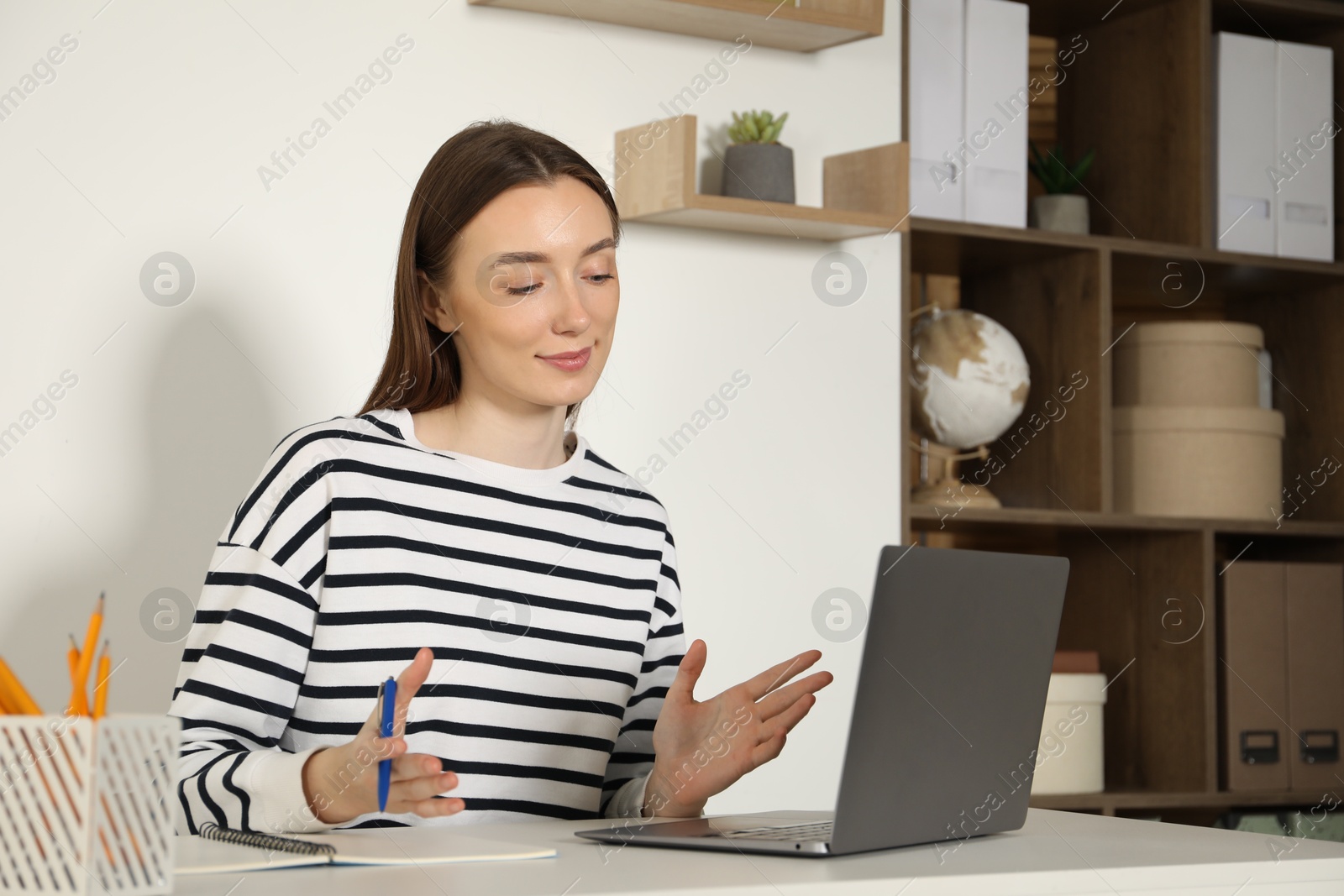 Photo of Woman having online lesson with teacher by laptop at table indoors