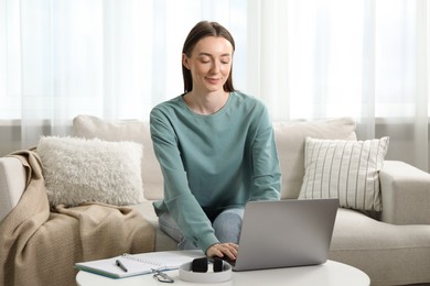 Photo of Woman learning online using laptop at table indoors. Self-study