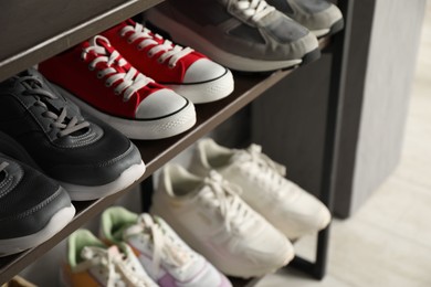 Photo of Shoe storage. Shelving unit with different footwear indoors, closeup