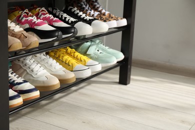 Photo of Shoe storage bench with different footwear indoors, closeup. Space for text